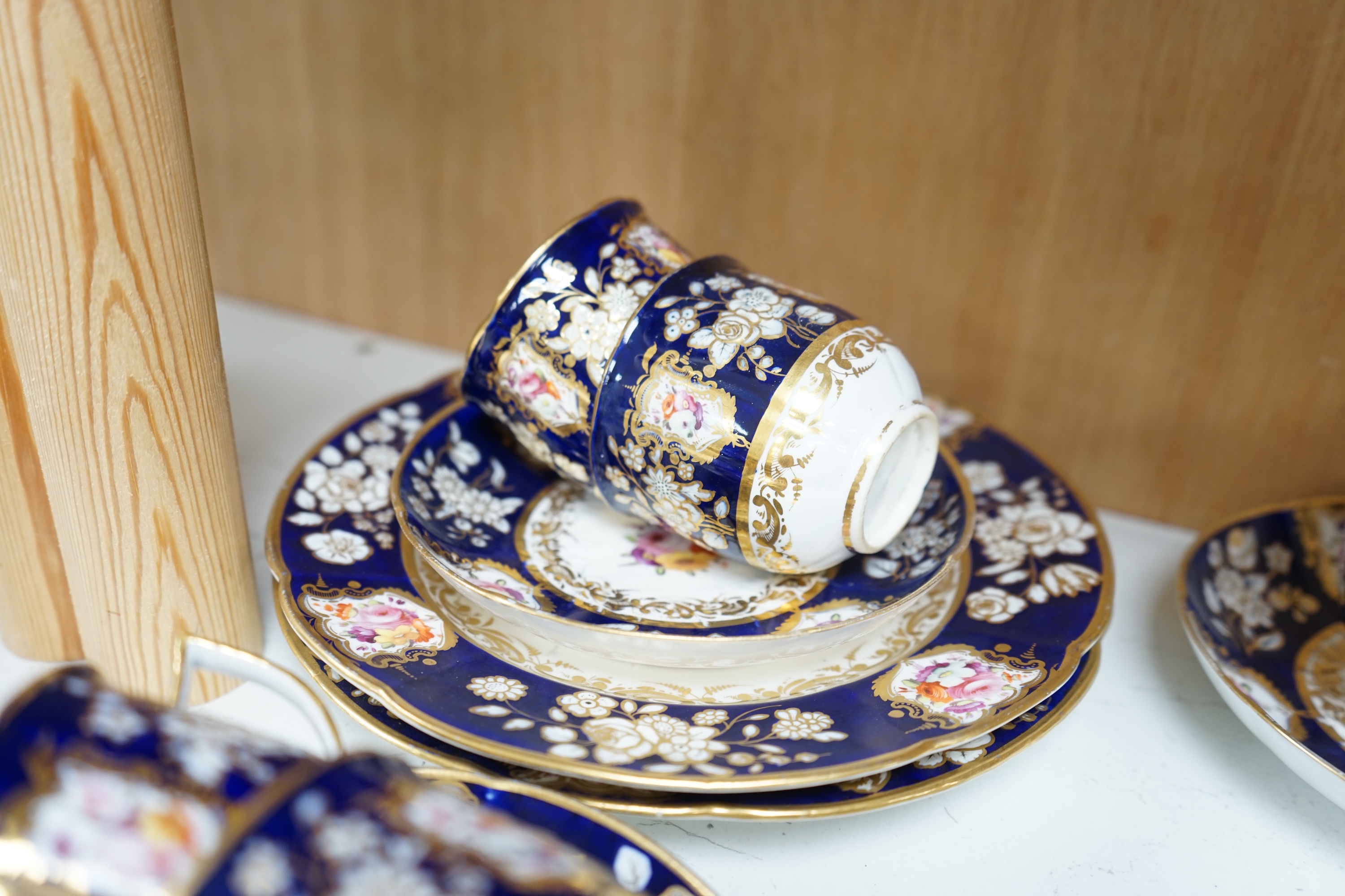 An early 19th century English porcelain tea service, possibly Coalport, moulded in low relief with floral reserves and cobalt blue border. Condition - varies